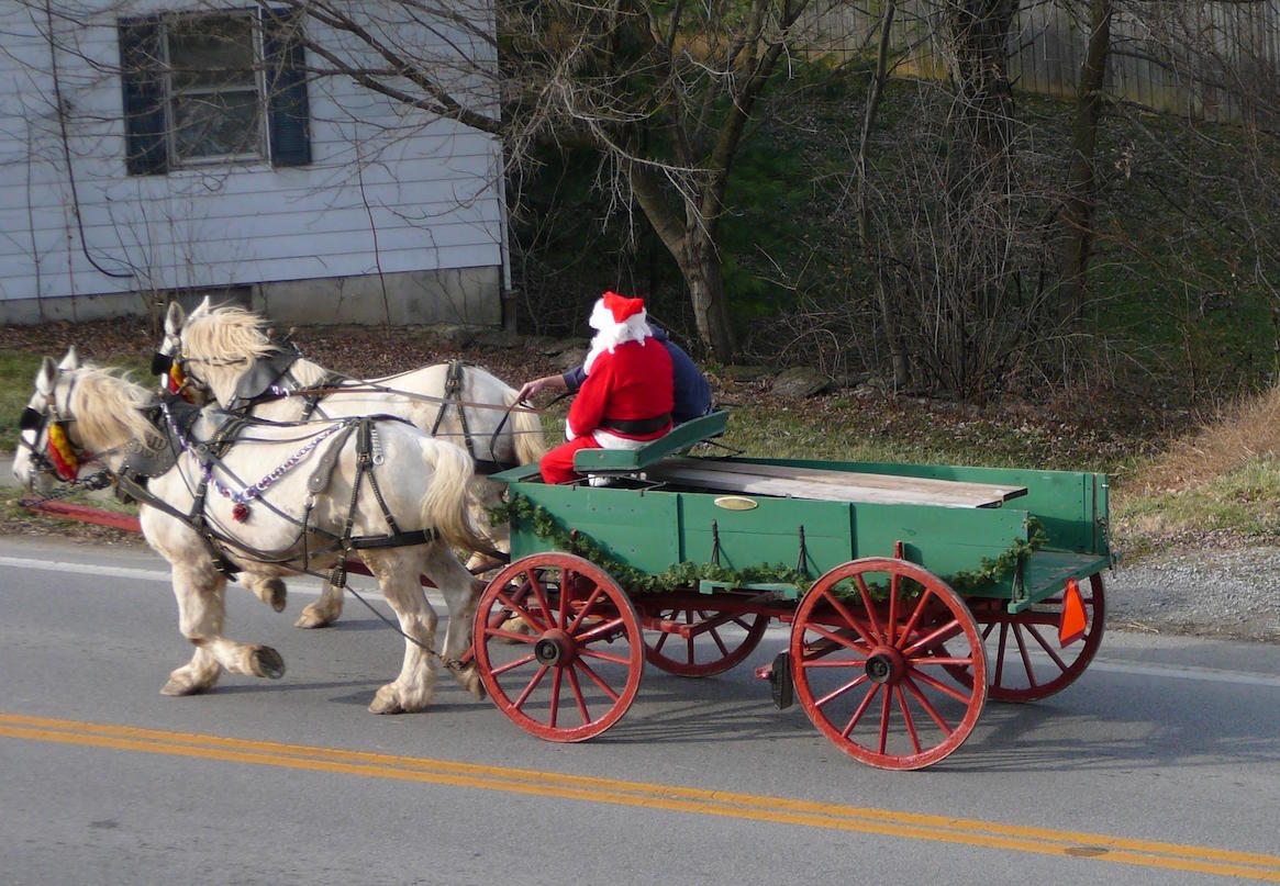 Santa rides a horse-drawn carriage